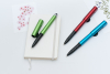 綠色多功能筆開蓋展示銀色筆尖細節，並呈現具備手機支架功能的筆夾設計。